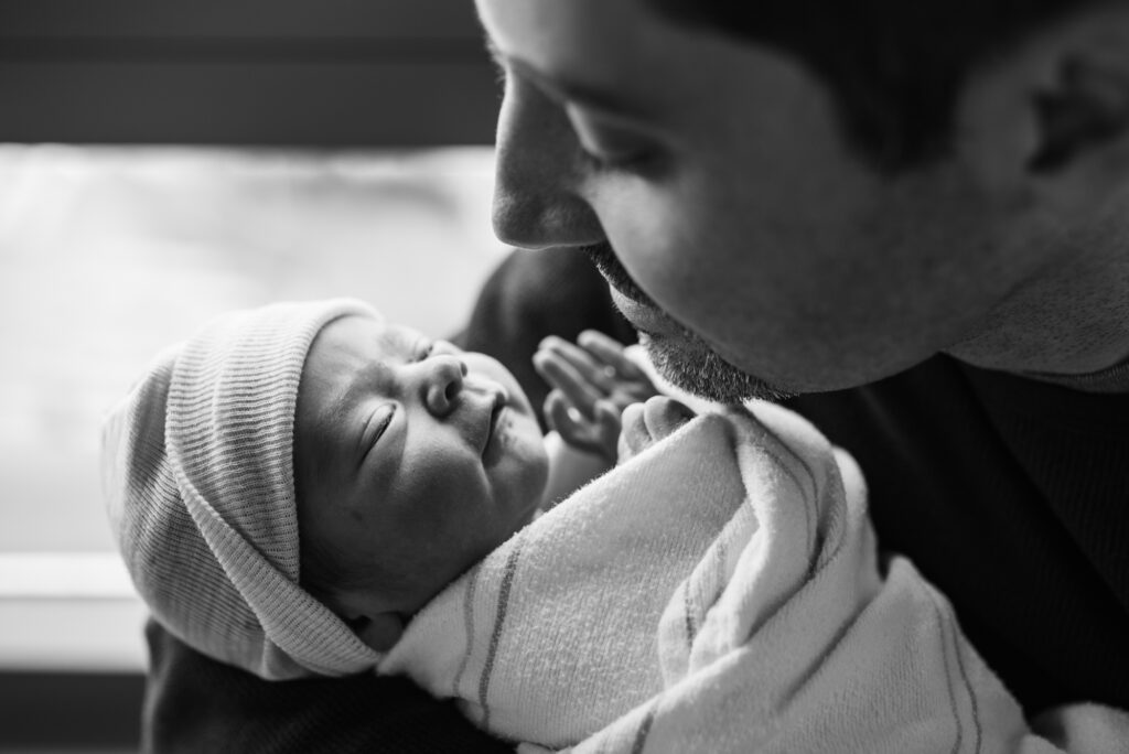 Black and white image of dad looking at his newborn on a beautiful father's day 2017 right after birth photographed by Los Angeles birth photographer and videographer Diana Hinek for Dear Birth