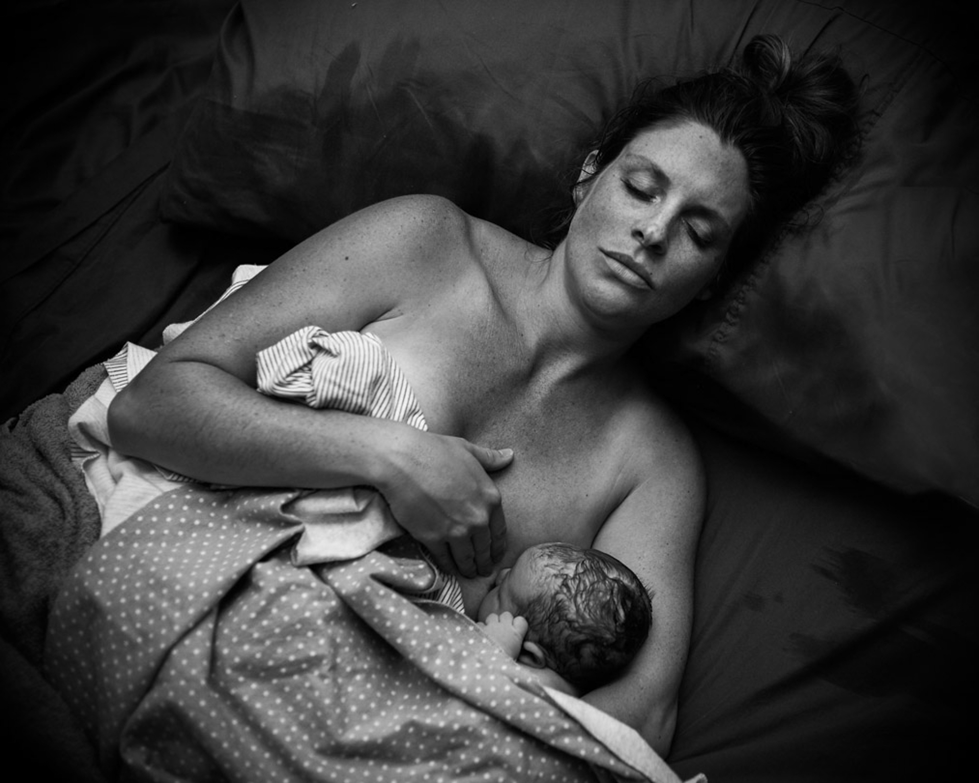 Black and white image of mother nursing her baby right after birth as captured by Los Angeles Birth photographer and videographer Diana Hinek for Dear Birth