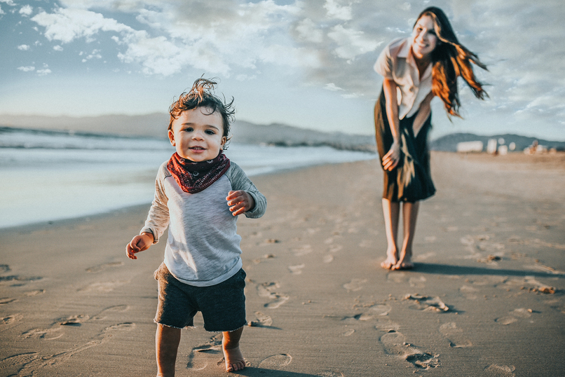 Color image of taddler walking away from mom and toward camera as portrayed by Los Angeles Santa Monica family Photographer Diana Hinek for Dear Birth