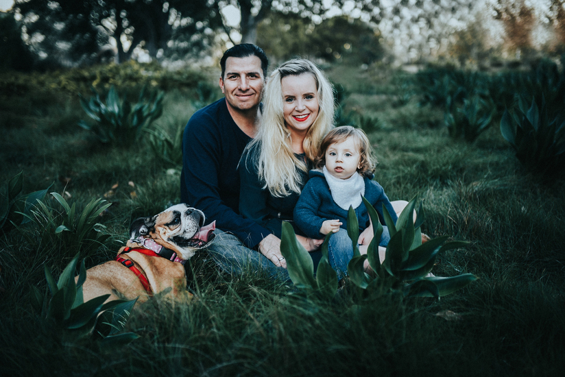 Family of three plus dog sit in the grass at Tongva park as photographed by Los Angeles Santa Monica family Photographer Diana Hinek for Dear Birth