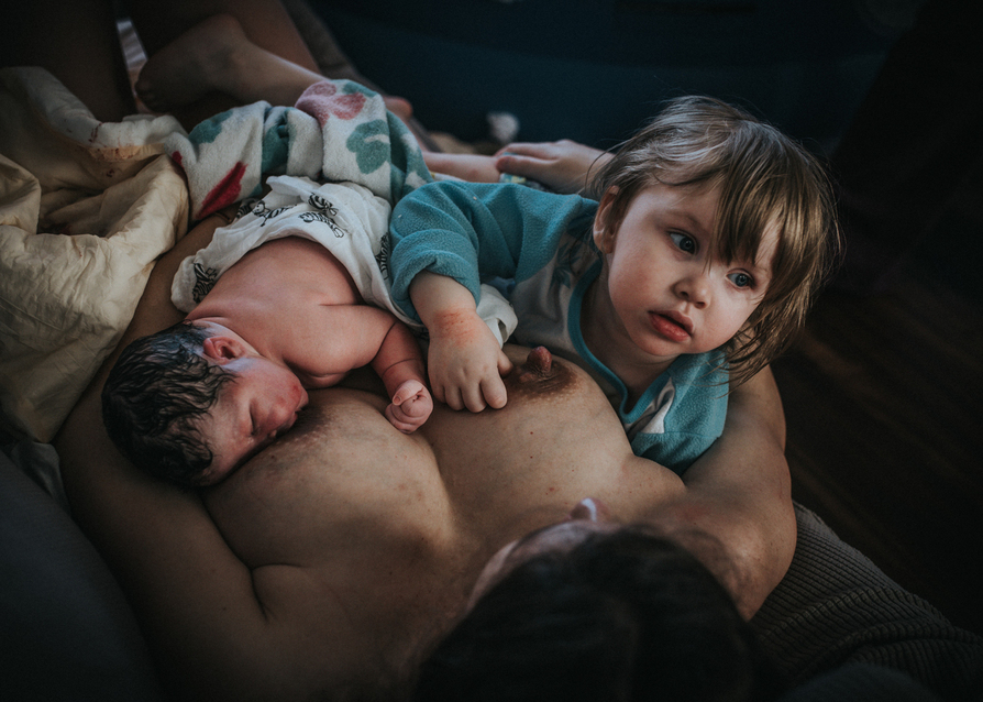 Top view of mother breastfeeding her newborn and toddler as captured by Los Angeles birth photographer and videographer Diana Hinek for Dear Birth