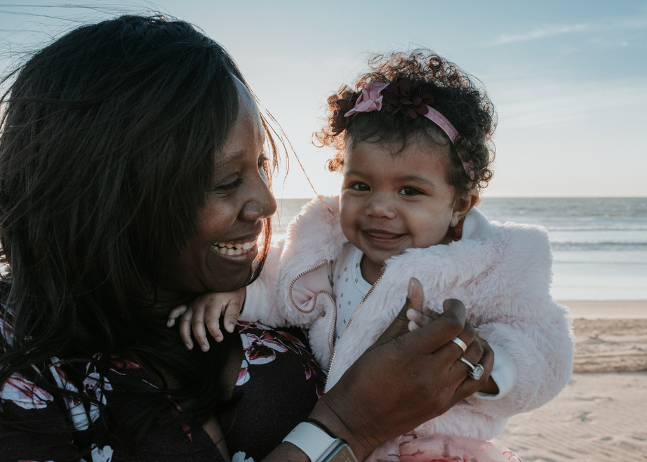 Color image of mother and daughter smiling at each other at the beach as photographed by Black and white image of Grandparents with all the grandchildren photographed by Los Angeles Family photographer Diana Hinek for Dear Birth
