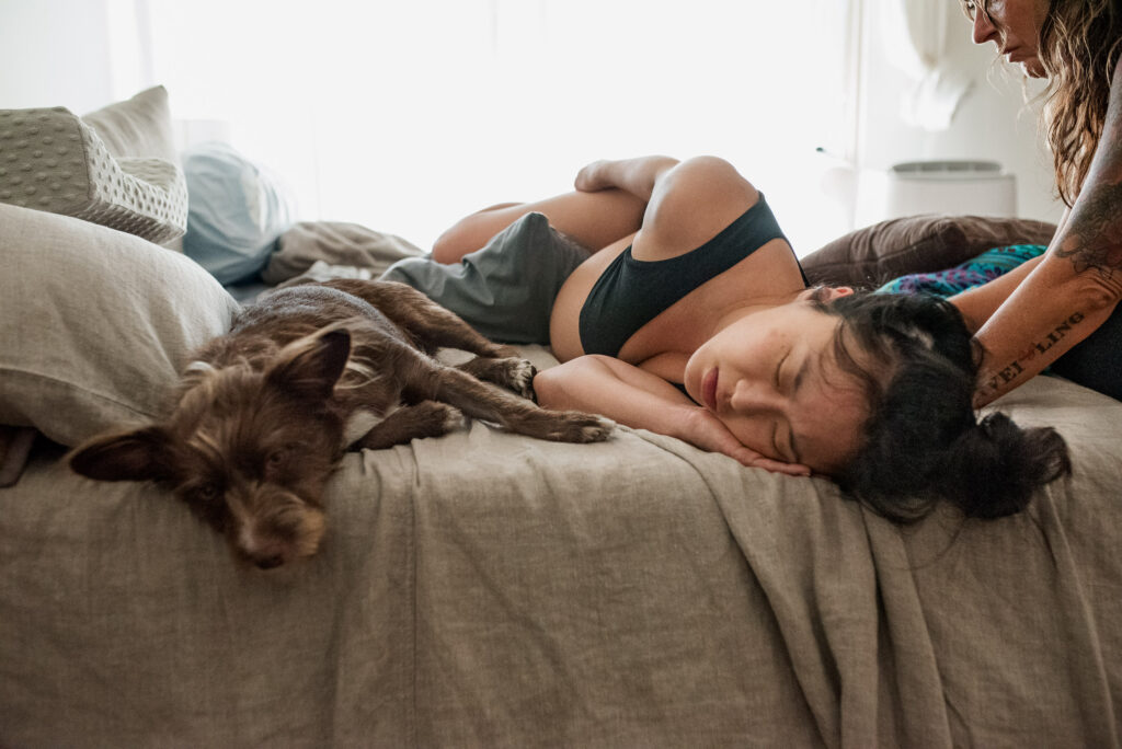 Color image of dog as emotional support, aka Guardian of the Journey, to mother in labor as captured by Los Angeles Birth photographer Diana Hinek for Dear Birth